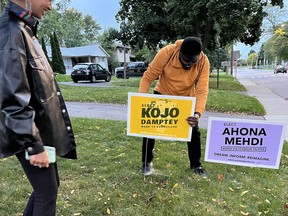 Hamilton city council candidate Kojo Damptey (right) campaigns with school board candidate Anona Mehdi for the Oct. 24 municipal election in a handout photo. Hamilton police's hate crime unit is investigating after a sticker saying "white people first" was placed on one of Damptey's campaign ads, along with two other hate-related election incidents.