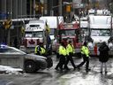 Police officers patrol on foot along Albert Street as a protest against COVID-19 restrictions that has been marked by gridlock and the sound of truck horns reaches its 14th day, in Ottawa, Thursday, Feb. 10, 2022.