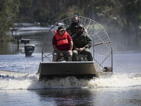 A rescue team evacuates a resident in a neighborhood flooded by the rising Myakka River in the wake of Hurricane Ian on October 1, 2022 in North Port, Florida.