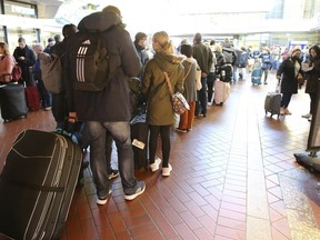 Travelers stand in long lines in Hamburg Central Station after long-distance services in northern Germany came to a standstill Saturday, Oct.8, 2022.