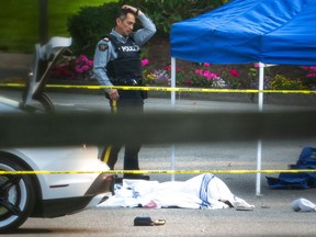 A body is seen covered in the parking lot of the University of British Columbia Golf Club parking lot in Vancouver, B.C., Monday, Oct. 17, 2022.