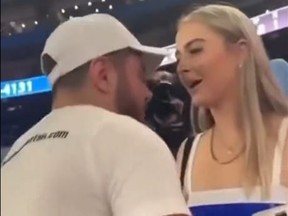 Screen shot of man about to propose to girlfriend at Blue Jays game.