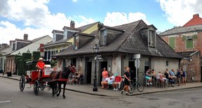A horse-drawn carriage rolls past Lafitte’s Blacksmith Shop Bar on Bourbon Street in New Orleans. (DAVE POLLARD/Toronto Sun)