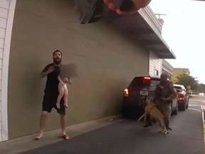 Man holding baby as shield before police officer uses Taser on him.