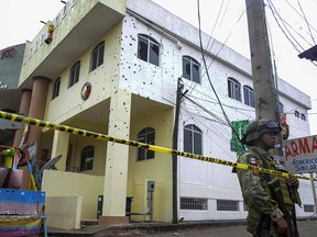 A member of the Mexican Army stands guard in front of the bullet-ridden building of the Municipality of San Miguel Totolapan, state of Guerrero, Mexico, on October 2022.
