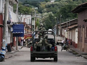 Soldiers patrol after a mass shooting that killed 20 people at the town hall of San Miguel Totolapan, Mexico, Oct. 6, 2022.