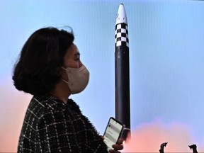 Eine Frau geht am 6. Oktober 2022 auf einem Bahnhof in Seoul an einem Fernsehbericht vorbei, der eine Nachrichtensendung mit Dateiaufnahmen eines nordkoreanischen Raketentests zeigt
