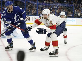 Florida Panthers center Eric Staal (12) deflects the puck away from Tampa Bay Lightning defenseman Philippe Myers (5) during the first period of an NHL preseason hockey game Saturday, Oct. 8, 2022, in Tampa, Fla.