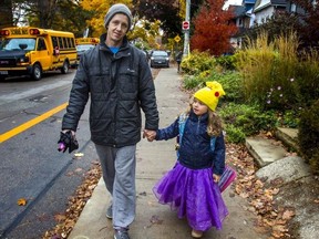 Chezeray Michaud and his daughter, Skylar, are pictured outside of Duke of Connaught Public School, near Queen St. E. and Coxwell Ave., on  Oct. 31, 2022.