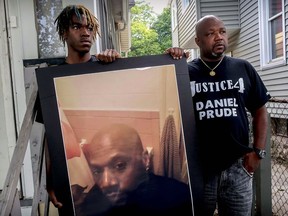 Armin Prude, left, and Joe Prude hold an enlarged photo of Daniel Prude, Sept. 3, 2020, who died following a police encounter, in Rochester, N.Y.