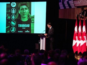 Prime Minister Justin Trudeau references a joke image of himself with a mullet haircut during his speech at the Parliamentary Press Gallery Dinner at the Museum of History in Gatineau, Que., on Saturday, Oct. 22, 2022.