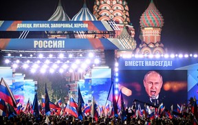Russian President Vladimir Putin is seen on a screen set at Red Square as he addresses a rally and a concert marking the annexation of four regions of Ukraine Russian troops occupy — Lugansk, Donetsk, Kherson and Zaporizhzhia, in central Moscow on Sept. 30, 2022.