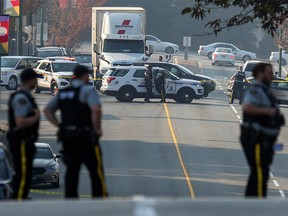 RCMP officers are seen near the site where a female member of the RCMP was stabbed to death in Burnaby, B.C., Tuesday, Oct. 18, 2022.