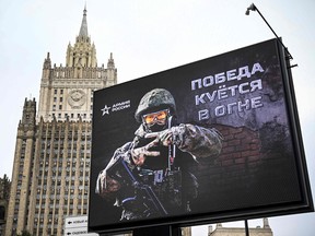 Russian Foreign Ministry is seen behind a social advertisement billboard showing Z letters -- a tactical insignia of Russian troops in Ukraine and reading "Victory is being Forged in Fire" in Moscow on October 13, 2022.