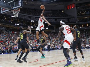 Raptors' Scottie Barnes throws down a dunk over top of Jazz guard Jordan Clarkson in Edmonton last night.