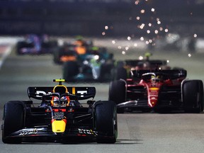 Sergio Perez, driving the (11) Oracle Red Bull Racing RB18, leads Charles Leclerc of Monaco during the Grand Prix of Singapore at Marina Bay Street Circuit on October 2, 2022 in Singapore.