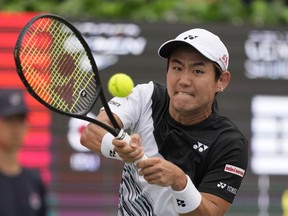 Yoshihito Nishioka of Japan returns a shot to Aleksandar Kovacevic of the United States during their semifinal match of the Korea Open tennis championships in Seoul, South Korea, Saturday, Oct. 1, 2022.