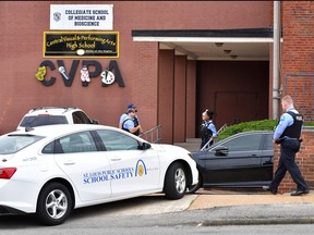 St. Louis metropolitan police officers stand outside an entrance at the northeast corner of the Central Visual and Performing Arts High School after a shooting that left three people dead including the shooter in St Louis, Miss., on Oct. 24, 2022.