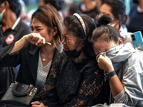 Relatives of victims cry as coffins are opened at Wat Si Uthai temple on October 7, 2022 in Uthai Sawan subdistrict, Nong Bua Lamphu, Thailand.