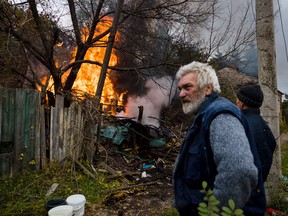 Russia withdraws officers from Kherson ahead of advance 2 Local residents stand near a burning structure after the shelling of the town of Bakhmut in Donbass region in eastern Ukraine on October 23, 2022.