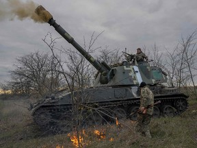 Ukrainian artillery unit members fire towards Kherson on October 28, 2022.