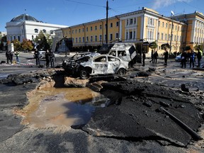 Police experts examine destroyed cars in the centre of Kyiv after several Russian strikes on October 10, 2022.