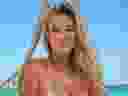 Model Veronika Rajek posing in swimsuit on beach.
