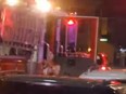 Woman wearing bikini sliding out of fire truck.