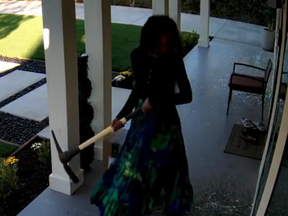Still image of pickaxe-wielding woman smashing windows of home in Pasadena, Calif.