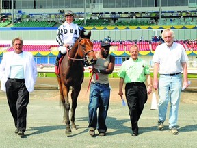 Long-time thoroughbred owner Hugh Galbraith (second from right) walks with trainer Dave Cotey (left) and jockey Chantal Sutherland aboard Mine That Bird. Galbraith passed away last week.