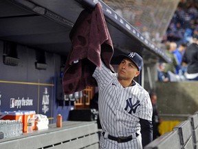 A New York Yankees ball boy dries off the roof of the dugout during a delay in Game 5 of the ALDS at Yankee Stadium.