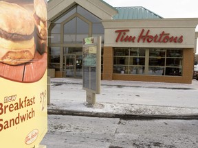 Tim Hortons reported that its fourth-quarter profit more than tripled, helped by sales of a new breakfast sandwich.