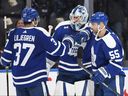 Toronto Maple Leafs goaltender Matt Murray (center) celebrates victory over the Buffalo Sabers with defenders Timothy Lillieglen (left) and Mark Giordano at Scotiabank Arena.