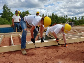 Habitat for Humanity  points to research that shows property values go up when you house people properly in a neighbourhood." Seen here: Global Village volunteers at Habitat PEI Lennox.