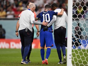 U.S. forward Christian Pulisic receives medical attention after injuring himself while scoring his team's first goal.