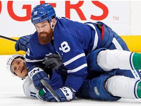 Jordie Benn of the Toronto Maple Leafs and Dakota Joshua of the Vancouver Canucks gets tangled up during the third period at the Scotiabank Arena on November 12, 2022 in Toronto, Ontario, Canada.