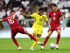 Gonzalo Plata of Ecuador controls the ball against Boualem Khoukhi (L) and Karim Boudiaf of Qatar during the FIFA World Cup Qatar 2022 Group A match between Qatar and Ecuador at Al Bayt Stadium on November 20, 2022 in Al Khor, Qatar.