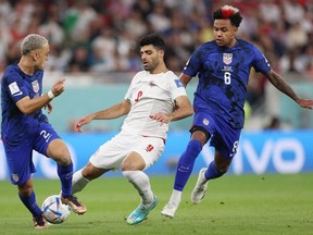 Weston McKennie of United States battles for possession with Mehdi Taremi of IR Iran during the FIFA World Cup Qatar 2022 Group B match between IR Iran and USA at Al Thumama Stadium.