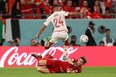 Tunisia defender Ali Abdi jumps over Denmark defender Joachim Andersen during the 2022 World Cup.