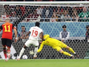 Thibaut Courtois of Belgium saves the penalty taken by Alphonso Davies of Canada.