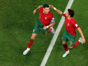 Cristiano Ronaldo (left) of Portugal celebrates with Joao Felix after scoring their team's first goal via a penalty against Ghana.