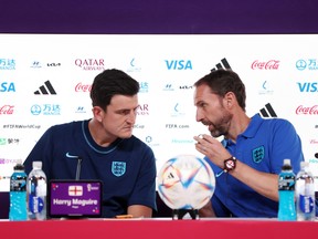 England's Harry Maguire and manager Gareth Southgate talk during a news conference.