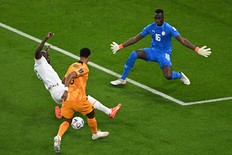 Senegal defender Kalidou Koulibaly (C) fights for the ball with Netherlands forward Cody Gakpo in front of Senegal goalkeeper Edouard Mendy.