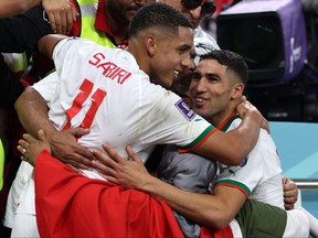 Morocco's Achraf Hakimi (R) and Abdelhamid Sabiri are greeted at the end of the Qatar 2022 World Cup Group F football match between Belgium and Morocco.