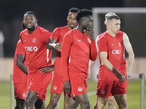 Canada’s Doneil Henry (left) an injured defender who’s with the team in a non-playing role walks with teammates during practice at the World Cup in Doha, Qatar on Tuesday.