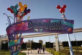 Pedestrians walk near the entrance to Disneyland Resort on February 19, 2009 in Anaheim, California. (Photo by David McNew/Getty Images)