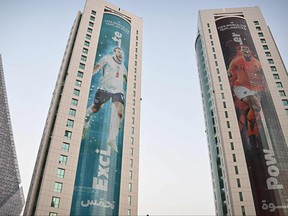 Banners depicting England's captain Harry Kane (L) and the Netherlands' captain Virgil van Dijk displayed on buildings in Doha on November 13, 2022 ahead of the Qatar 2022 World Cup football tournament. (Photo by Paul ELLIS / AFP)