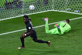 Canada’s Alphonso Davies celebrates scoring his team’s first goal past Croatia’s goalkeeper Dominik Livakovic during the Qatar 2022 World Cup Group F match at the Khalifa International Stadium in Doha on November 27, 2022. (Photo by JEWEL SAMAD/AFP via Getty Images)