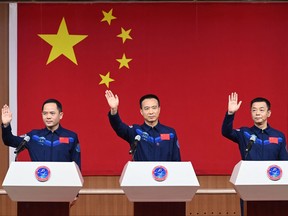 Chinese astronauts Fei Junlong (centre), Deng Qingming (right) and Zhang Lu (left), crew of the Shenzhou-15 spaceflight mission, wave at a press conference at the Jiuquan Satellite Launch Centre in Northwest Chinas Gansu Province on Nov. 28, 2022, a day before the scheduled launch.
