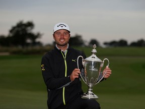 Adam Svensson of Surrey, B.C. poses with the trophy after winning the RSM Classic at Sea Island Golf Club in Georgia on Sunday.